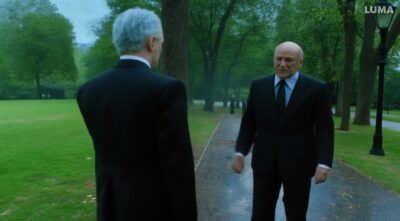 man with gray hair wearing a suit, walks in the park on a rainy day and meet hi-a209f9