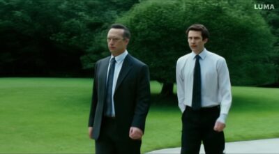 man in a suit walks in a park and sees himself walking in the park, then they greet each other-055adb